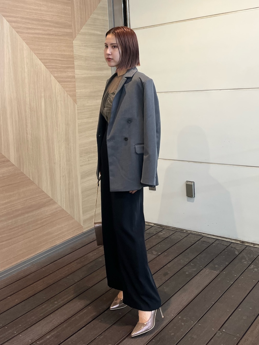 ゴールド系のハンドバッグ、その他のパンツドレス、グレー系のテーラードジャケットを着用したレディースの秋コーディネートの2枚目の写真