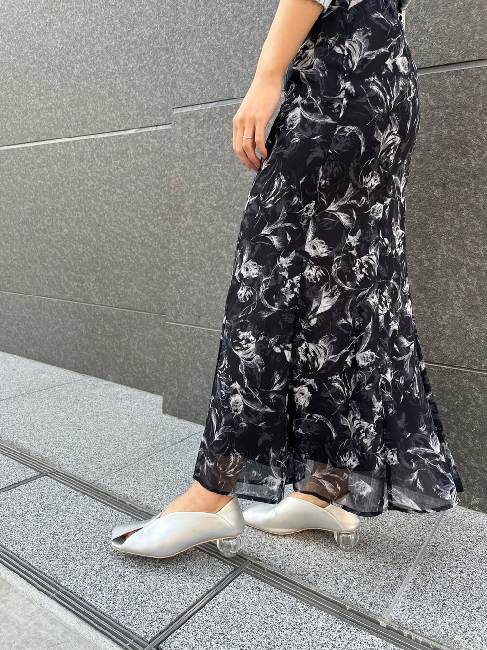 ブラック系のスカート、シルバー系のパンプス、ブルー系のニット/セーターを着用したレディースの春コーディネートの6枚目の写真