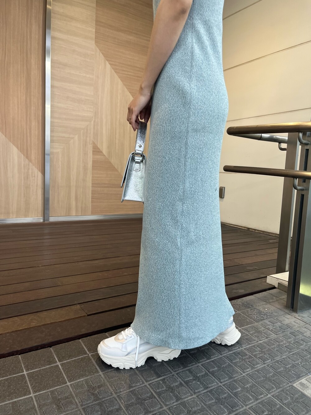 シルバー系のショルダーバッグ、ホワイト系のスニーカー、ブルー系のワンピースを着用したレディースの春コーディネートの7枚目の写真