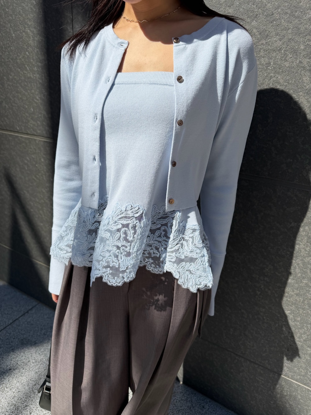 ブルー系のトレンチコート、グレー系のその他パンツ、ブラック系のハンドバッグを着用したレディースの冬コーディネートの9枚目の写真