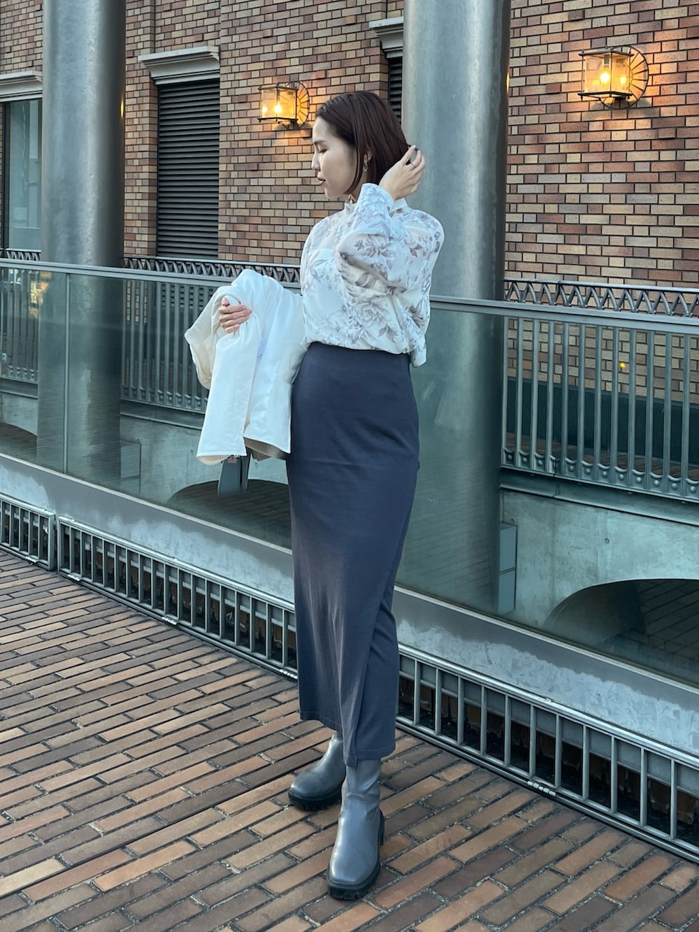 ブルー系のショルダーバッグ、グレー系のスカート、ホワイト系のブルゾンを着用したレディースの冬コーディネートの5枚目の写真