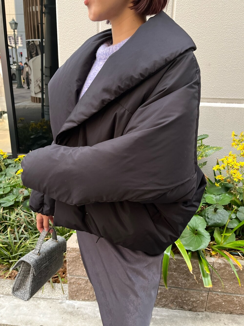 グレー系のスカート、パープル系のニット/セーター、ブラック系のダウンジャケット/コートを着用したレディースの冬コーディネートの7枚目の写真