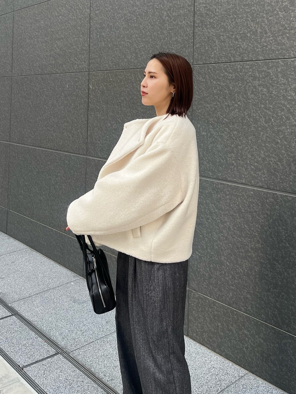 グレー系のその他パンツ、ホワイト系のニット/セーター、ホワイト系のブルゾンを着用したレディースの冬コーディネートの6枚目の写真