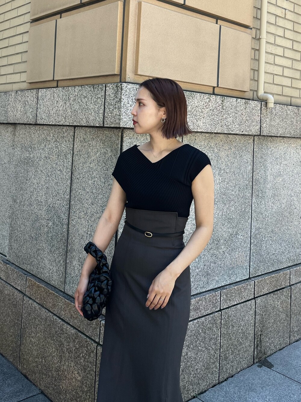 グレー系のスカート、ブラック系のサンダル、ブラック系のハンドバッグを着用したレディースの夏コーディネートの4枚目の写真