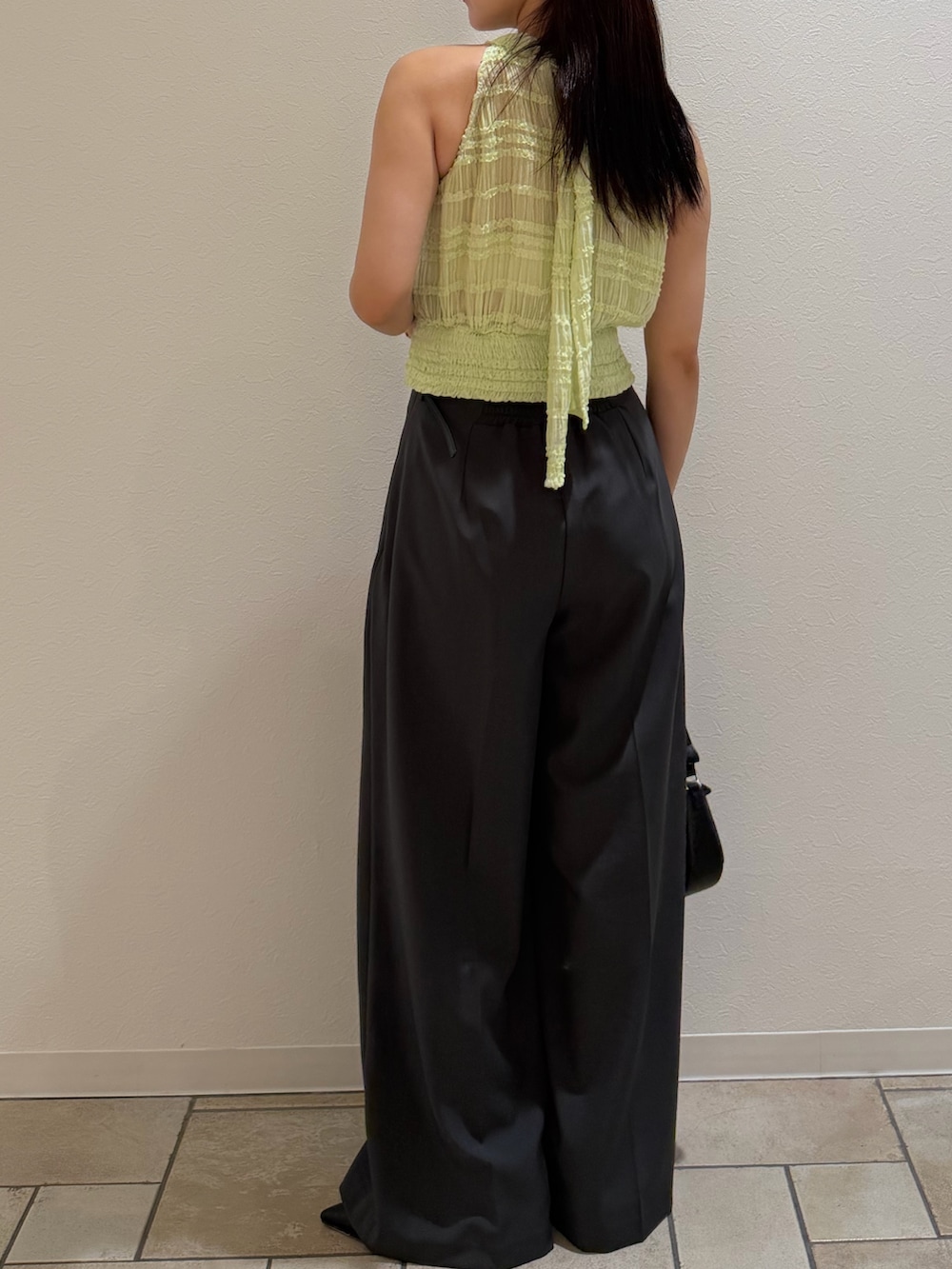 グレー系のその他パンツ、グリーン系のシャツ/ブラウス、ブラック系のハンドバッグを着用したレディースの夏コーディネートの3枚目の写真