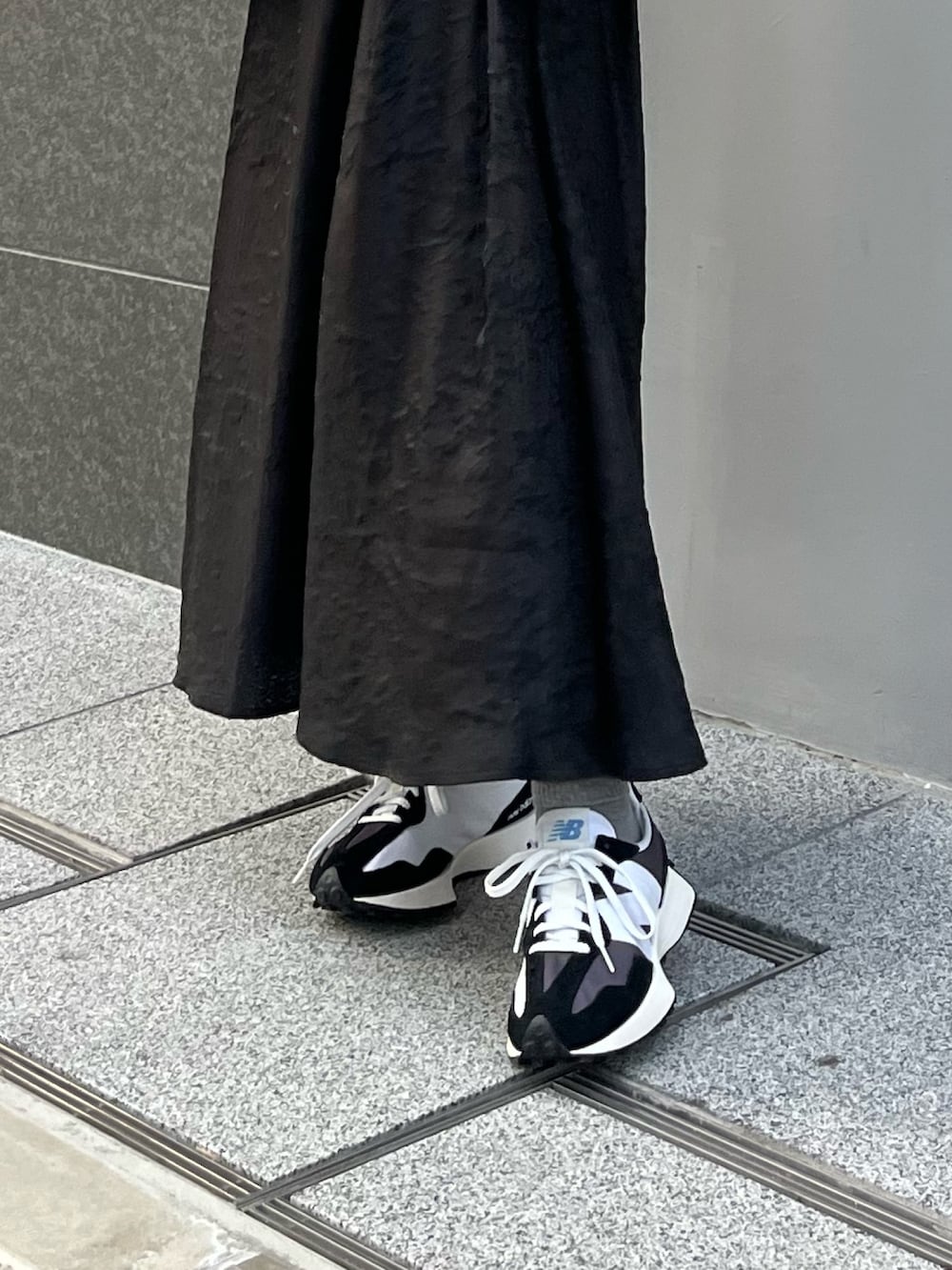 ホワイト系のダウンジャケット/コート、ブルー系のニット/セーター、ブラック系のスカートを着用したレディースの冬コーディネートの7枚目の写真