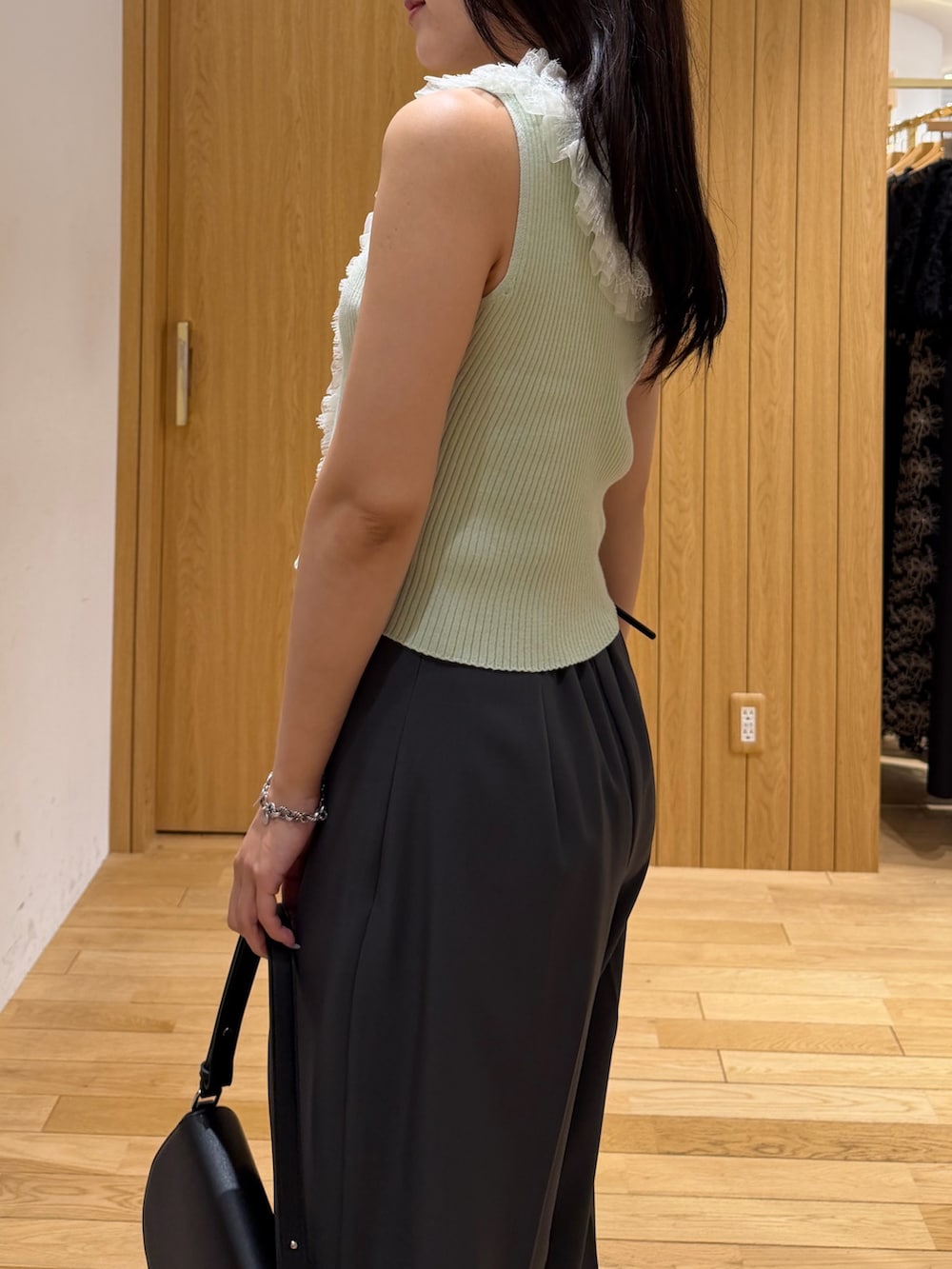 グレー系のその他パンツ、ブラック系のハンドバッグ、グリーン系のニット/セーターを着用したレディースの夏コーディネートの5枚目の写真