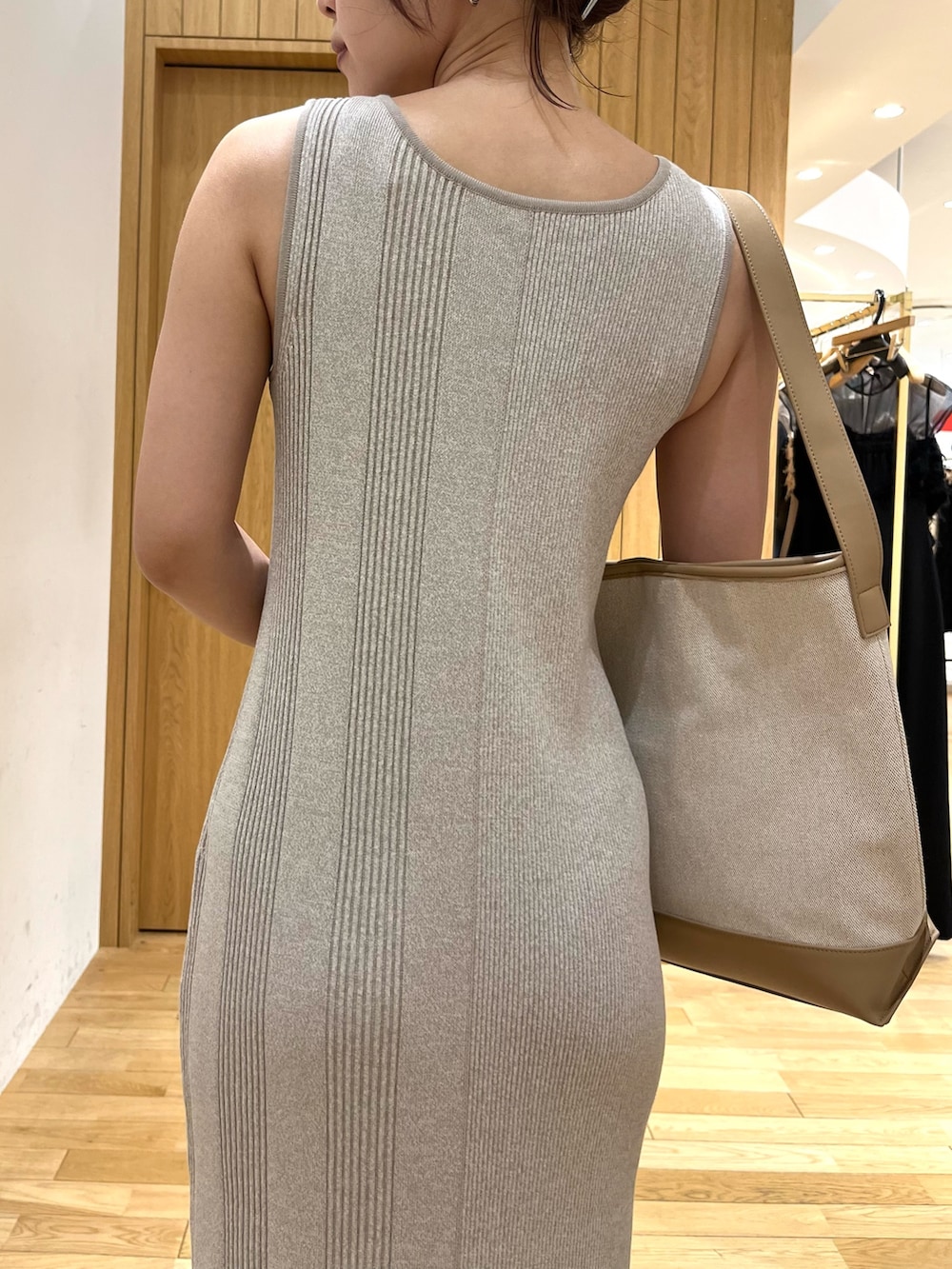 ベージュ系のワンピース、ホワイト系のスニーカー、ブラウン系のショルダーバッグを着用したレディースの夏コーディネートの5枚目の写真