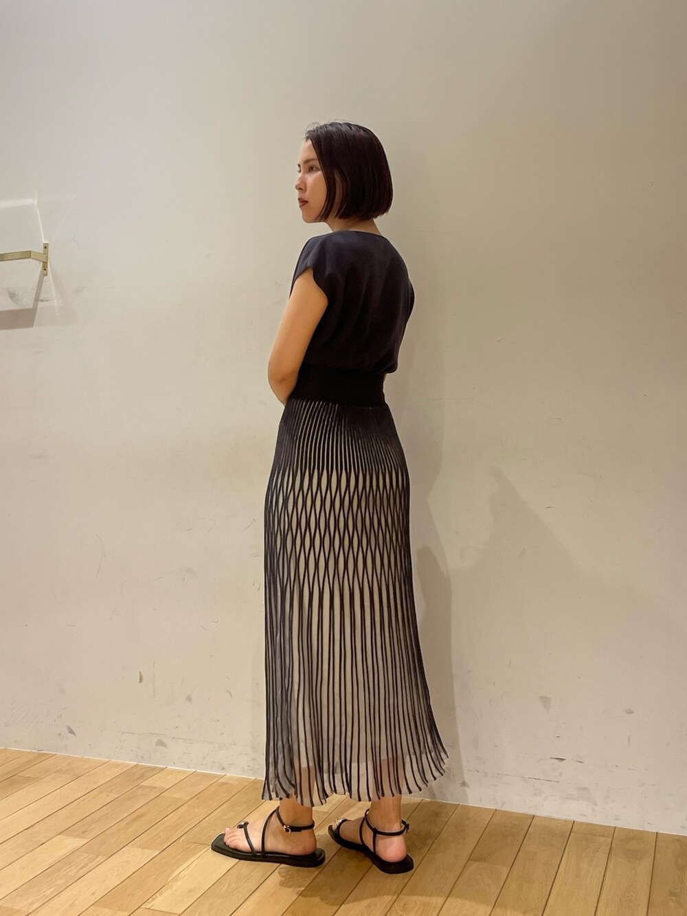 ブラック系のサンダル、グレー系のワンピース、ブルー系のハンドバッグを着用したレディースの夏コーディネートの3枚目の写真