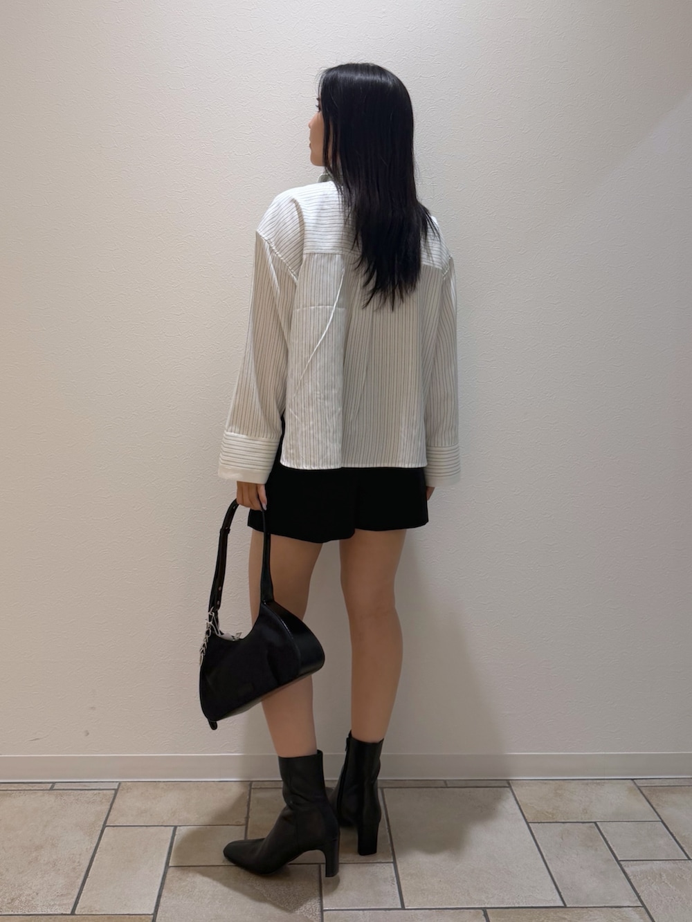 ブラック系のその他パンツ、ホワイト系のシャツ/ブラウス、ブラック系のブーツを着用したレディースの秋コーディネートの3枚目の写真