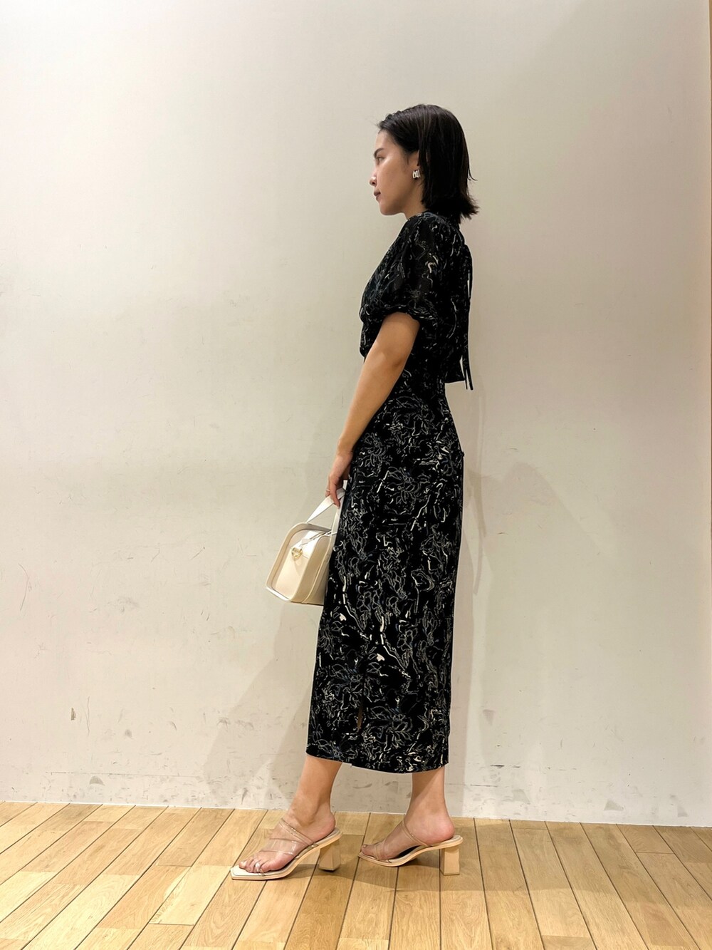 ブラック系のワンピース、その他のサンダル、ホワイト系のショルダーバッグを着用したレディースの夏コーディネートの3枚目の写真