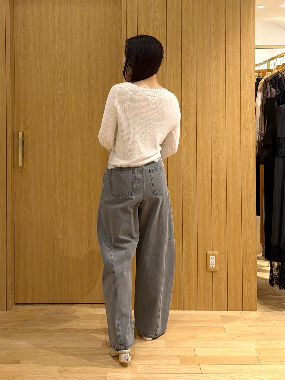 ホワイト系のカーディガン/ボレロ、グレー系のデニムパンツ、ブラウン系のハンドバッグを着用したレディースの秋コーディネートの3枚目の写真