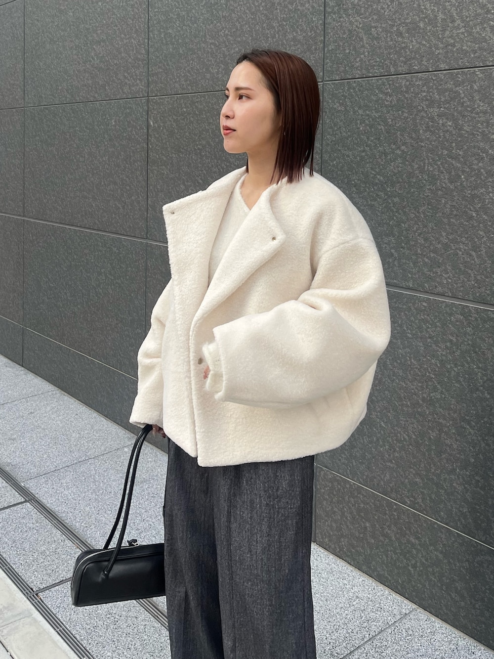 グレー系のその他パンツ、ホワイト系のニット/セーター、ホワイト系のブルゾンを着用したレディースの冬コーディネートの5枚目の写真