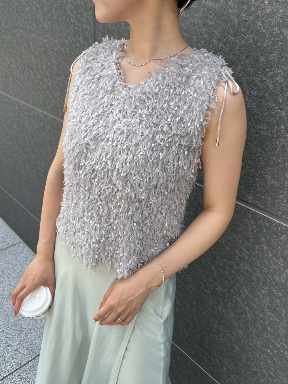 グレー系のTシャツ/カットソー、グリーン系のスカート、ホワイト系のサンダルを着用したレディースの夏コーディネートの7枚目の写真