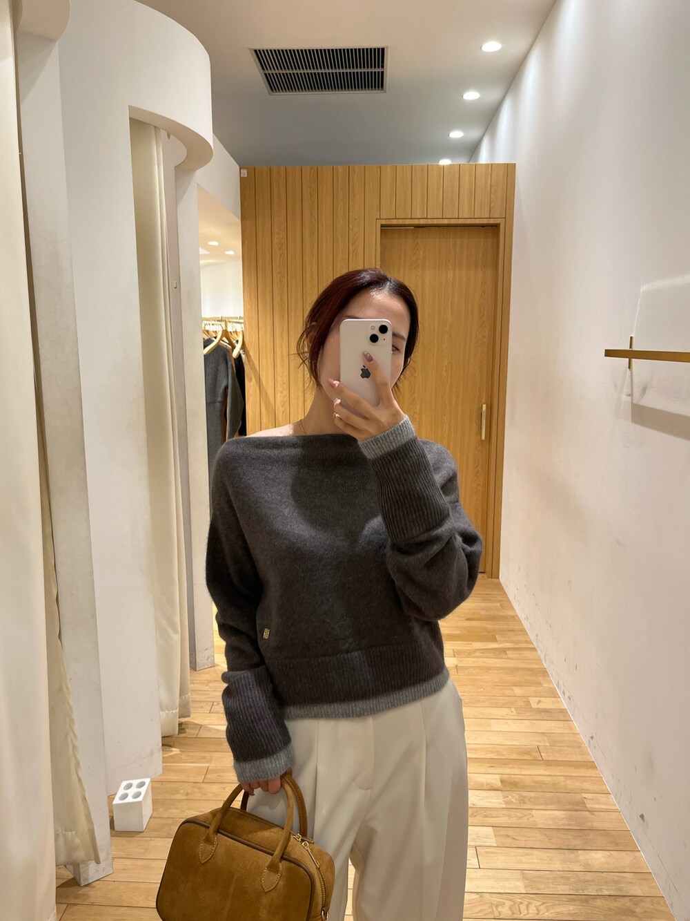 ホワイト系のその他パンツ、ブラック系のブーツ、ブラウン系のハンドバッグを着用したレディースの秋コーディネートの5枚目の写真