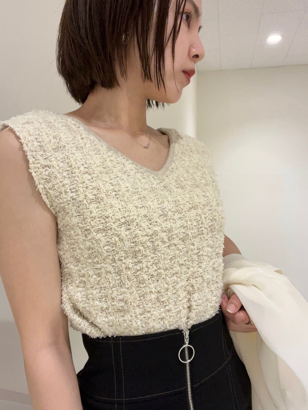 ホワイト系のニット/セーター、グリーン系のハンドバッグ、その他のサンダルを着用したレディースの春コーディネートの3枚目の写真