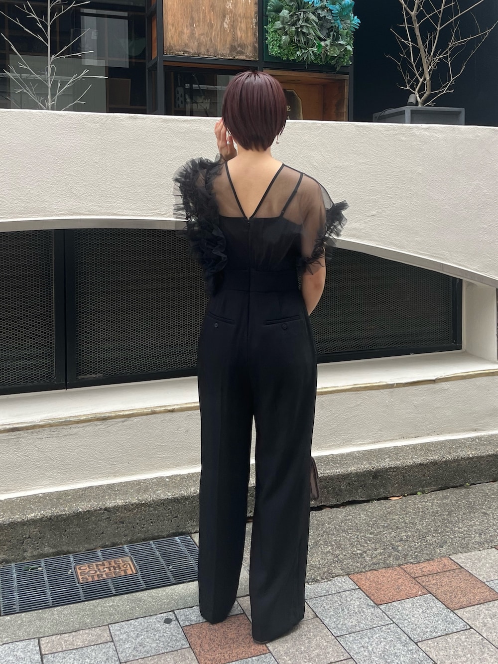 ブラック系のパンツドレス、その他のパンプス、シルバー系のハンドバッグを着用したレディースの冬コーディネートの3枚目の写真