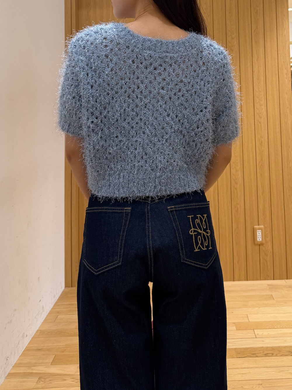 ブルー系のデニムパンツ、レッド系のハンドバッグ、ブルー系のニット/セーターを着用したレディースの秋コーディネートの5枚目の写真