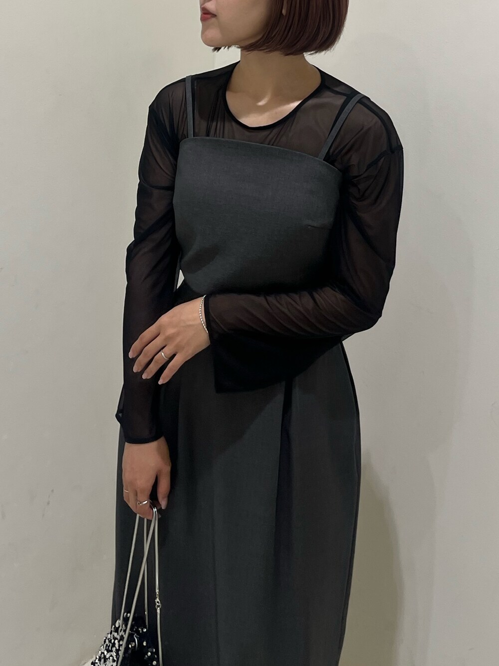 グレー系のドレス、ブラック系のパンプス、シルバー系のハンドバッグを着用したレディースの夏コーディネートの4枚目の写真