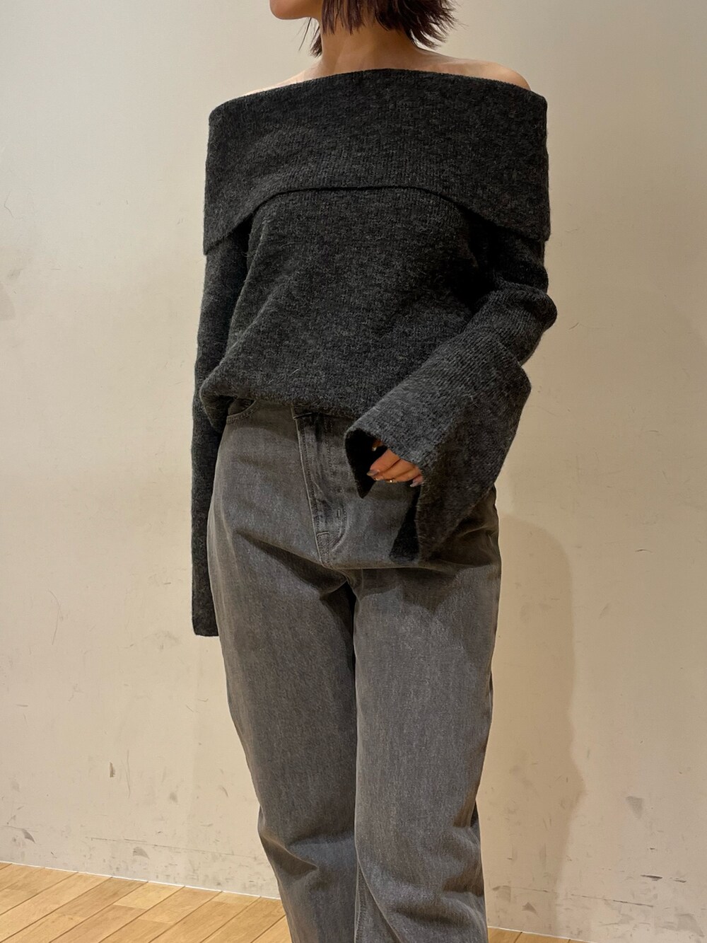 ブラック系のデニムパンツ、グレー系のニット/セーター、ブラック系のショルダーバッグを着用したレディースの秋コーディネートの4枚目の写真