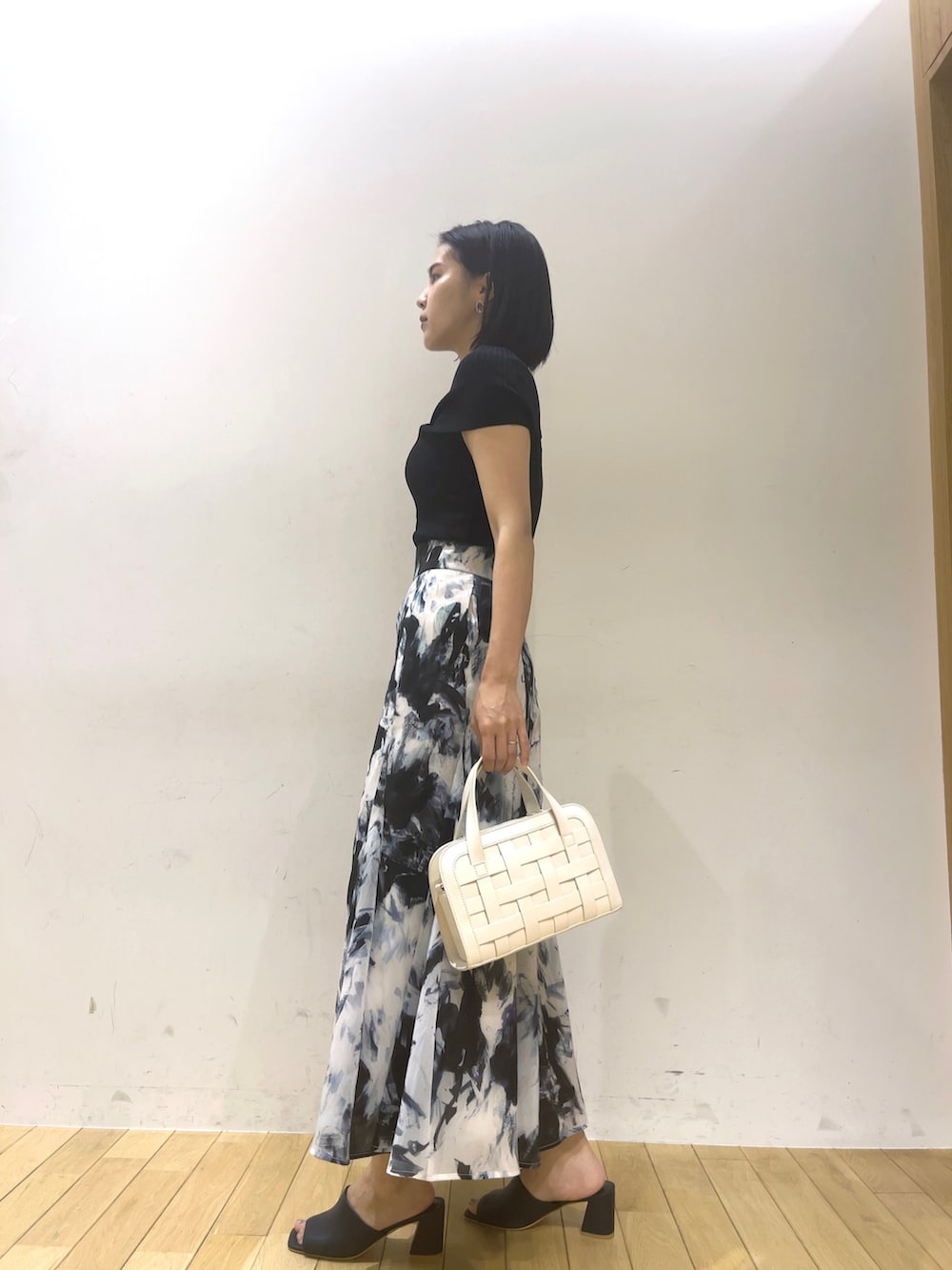 ブラック系のニット/セーター、ブルー系のサンダル、ホワイト系のショルダーバッグを着用したレディースの夏コーディネートの3枚目の写真