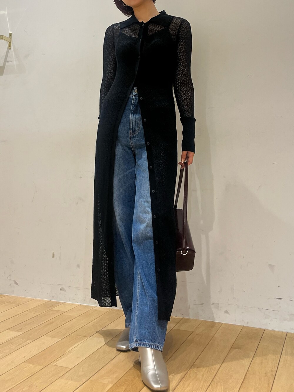 ブラック系のワンピース、レッド系のショルダーバッグ、シルバー系のブーツを着用したレディースの秋コーディネートの4枚目の写真