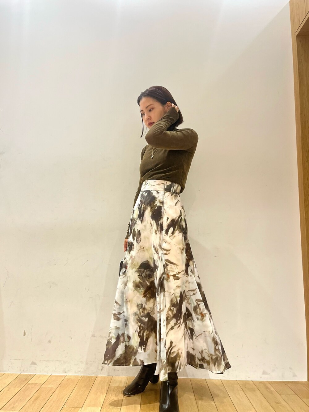 ベージュ系のテーラードジャケット、ブラウン系のTシャツ/カットソー、グリーン系のスカートを着用したレディースの秋コーディネートの2枚目の写真