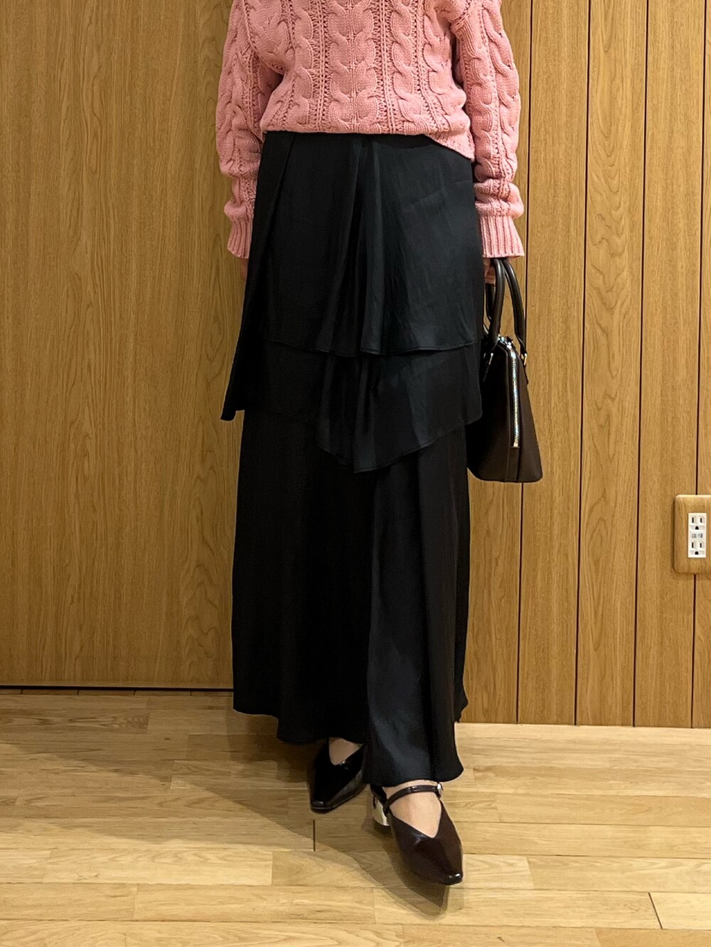 ブラウン系のパンプス、ブラック系のスカート、ピンク系のニット/セーターを着用したレディースの秋コーディネートの7枚目の写真