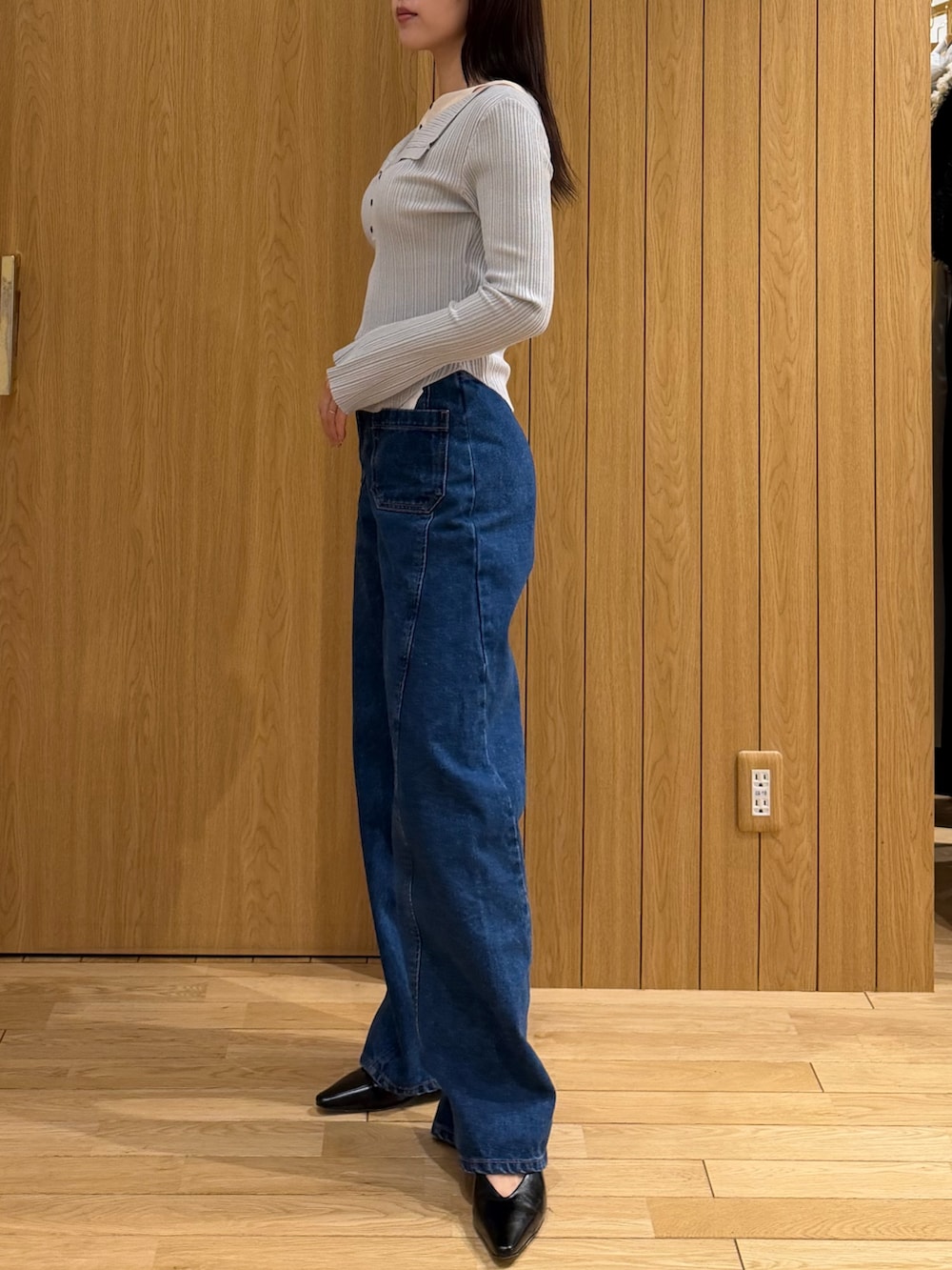 ブルー系のデニムパンツ、グレー系のニット/セーター、ブラック系のパンプスを着用したレディースの春コーディネートの2枚目の写真
