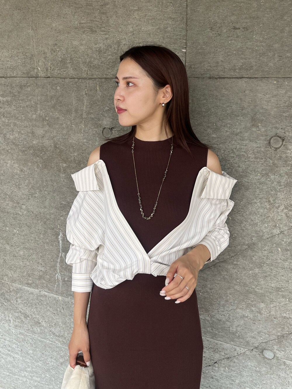 ブラウン系のパンプス、ホワイト系のハンドバッグ、ブラウン系のワンピースを着用したレディースの秋コーディネートの4枚目の写真