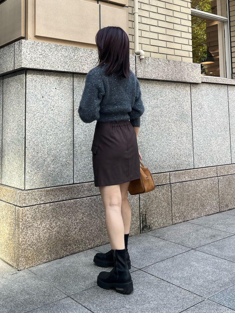 ブラウン系のハンドバッグ、グレー系のカーディガン/ボレロ、ブラウン系のスカートを着用したレディースの秋コーディネートの3枚目の写真
