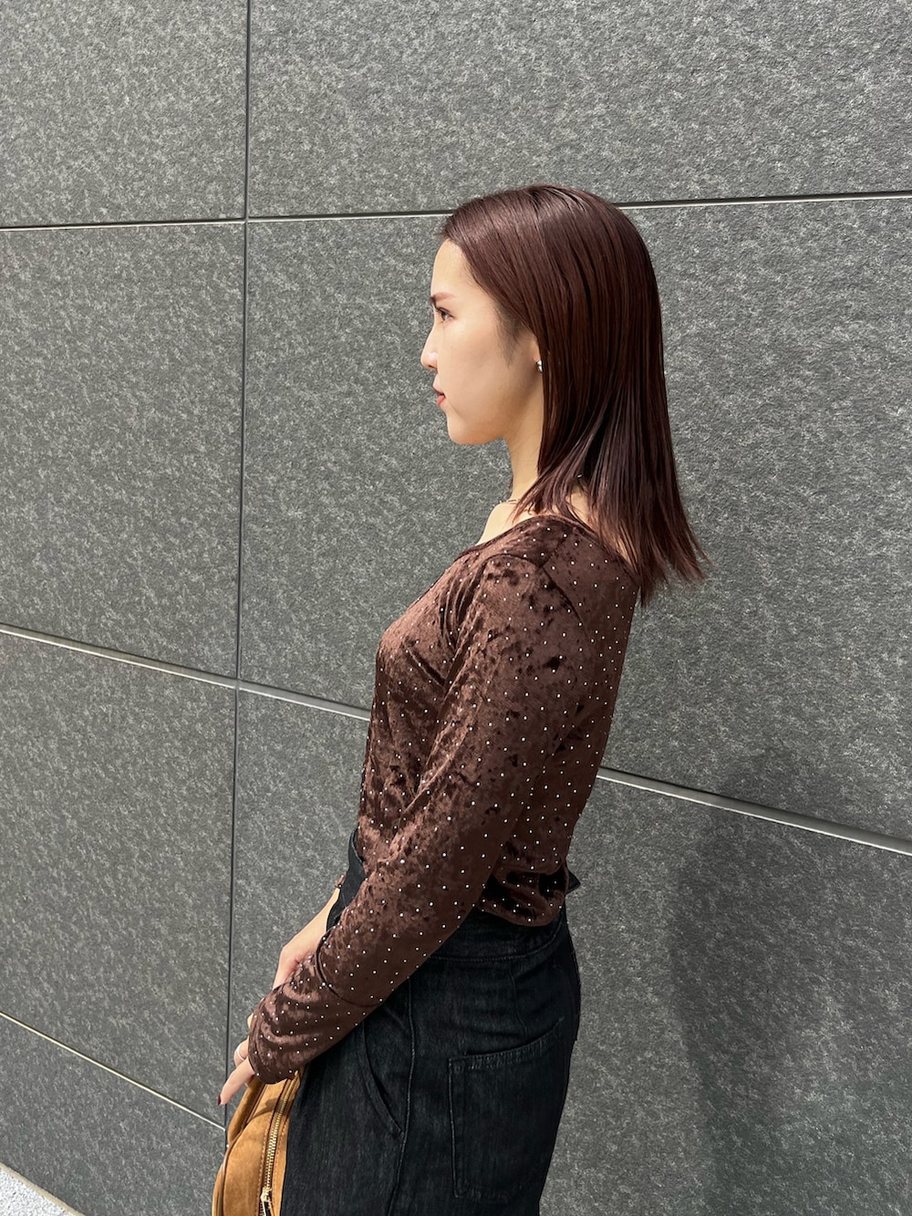 ブラック系のデニムパンツ、ブラウン系のハンドバッグ、ブラウン系のTシャツ/カットソーを着用したレディースの秋コーディネートの5枚目の写真