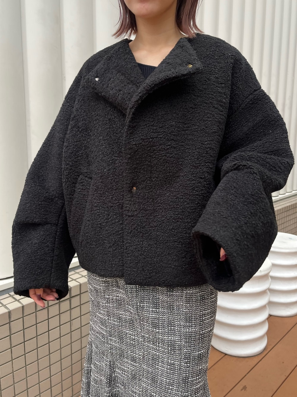 ブラック系のブルゾン、ブラック系のニット/セーター、ブラック系のスカートを着用したレディースの秋コーディネートの7枚目の写真