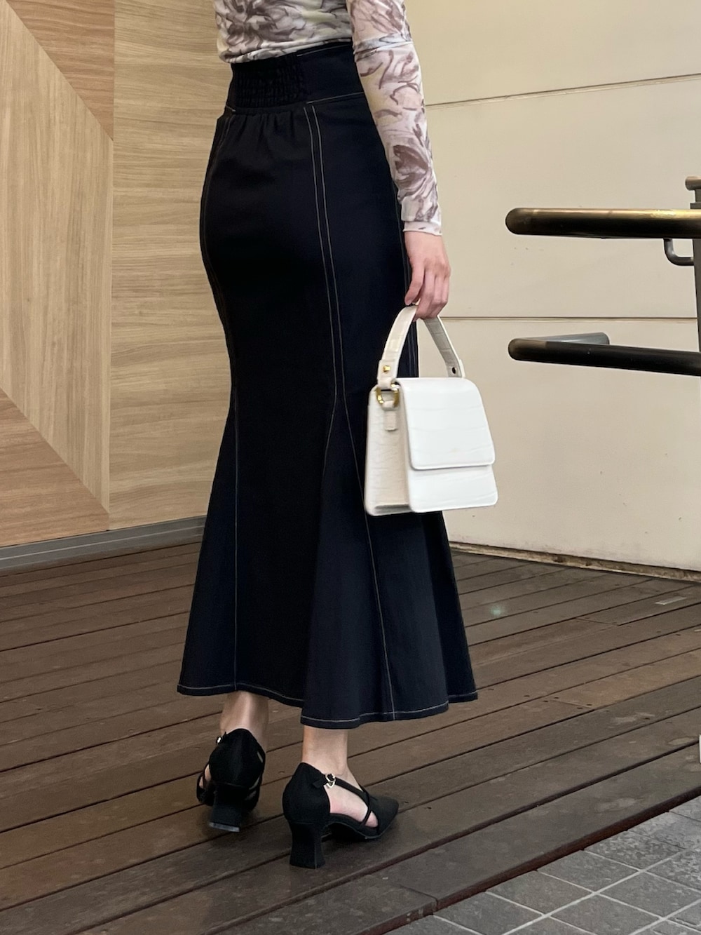 ブラック系のスカート、ブラック系のパンプス、イエロー系のTシャツ/カットソーを着用したレディースの春コーディネートの7枚目の写真