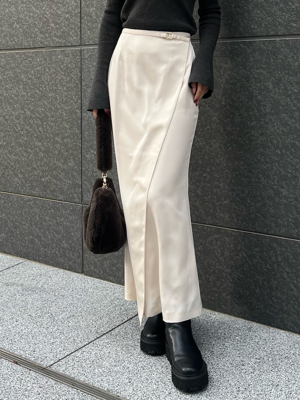 ホワイト系のスカート、ブラウン系のショルダーバッグ、ブラック系のニット/セーターを着用したレディースの冬コーディネートの4枚目の写真