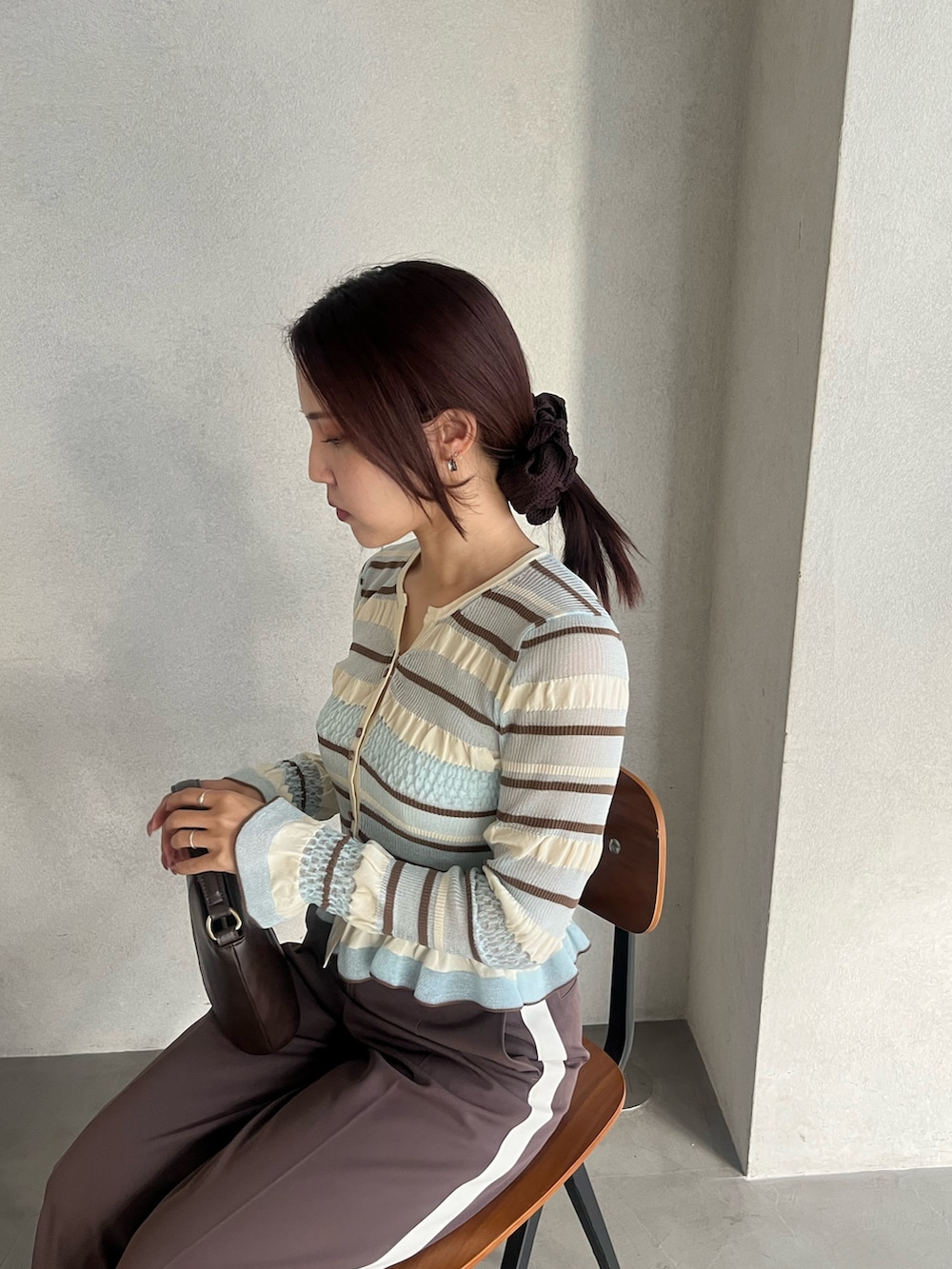 ブラウン系のハンドバッグ、ブラウン系のパンプス、ブラウン系のその他パンツを着用したレディースの冬コーディネートの4枚目の写真