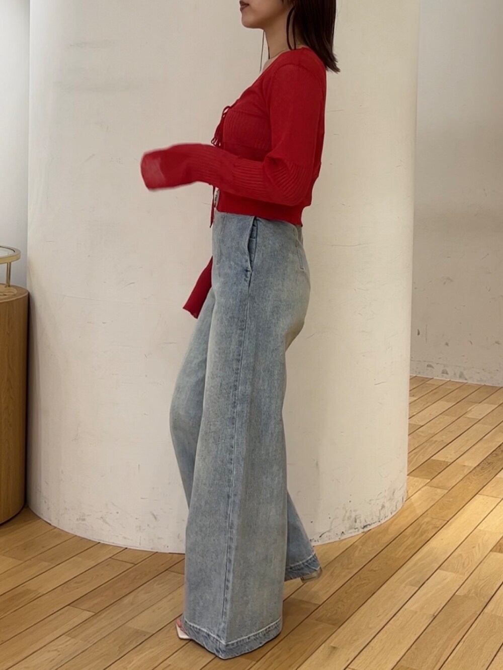 ブルー系のデニムパンツ、レッド系のカーディガン/ボレロ、ホワイト系のサンダルを着用したレディースの春コーディネートの2枚目の写真