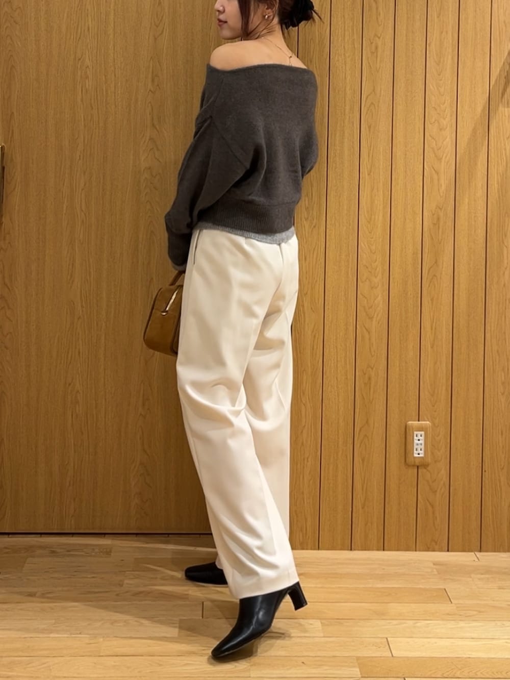ホワイト系のその他パンツ、ブラック系のブーツ、ブラウン系のハンドバッグを着用したレディースの秋コーディネートの2枚目の写真