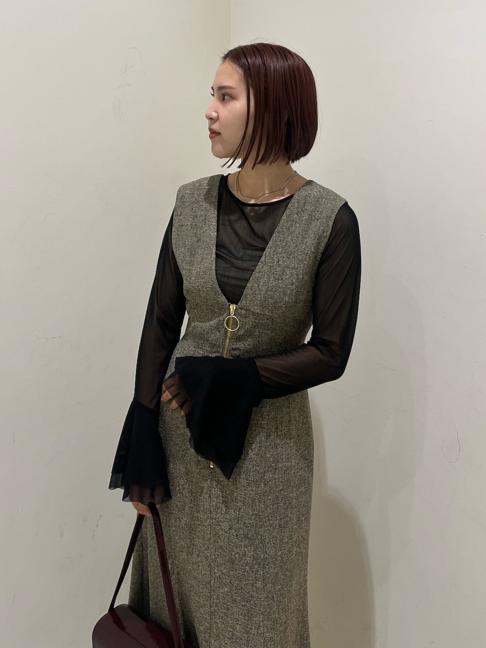 ベージュ系のジャンパースカート、ブラック系のTシャツ/カットソー、ブラック系のブーツを着用したレディースの秋コーディネートの4枚目の写真