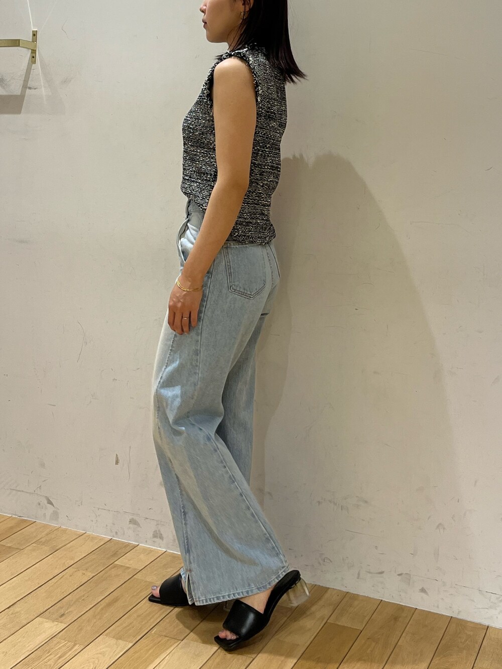 ブルー系のデニムパンツ、ブラック系のサンダル、ブラック系のニット/セーターを着用したレディースの夏コーディネートの2枚目の写真