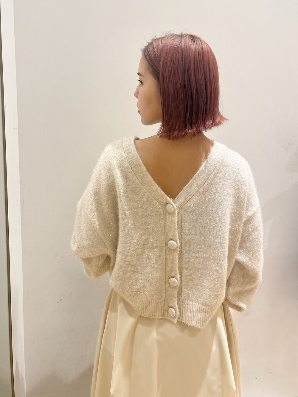 ホワイト系のスカート、ホワイト系のカーディガン/ボレロ、グリーン系のハンドバッグを着用したレディースの秋コーディネートの4枚目の写真