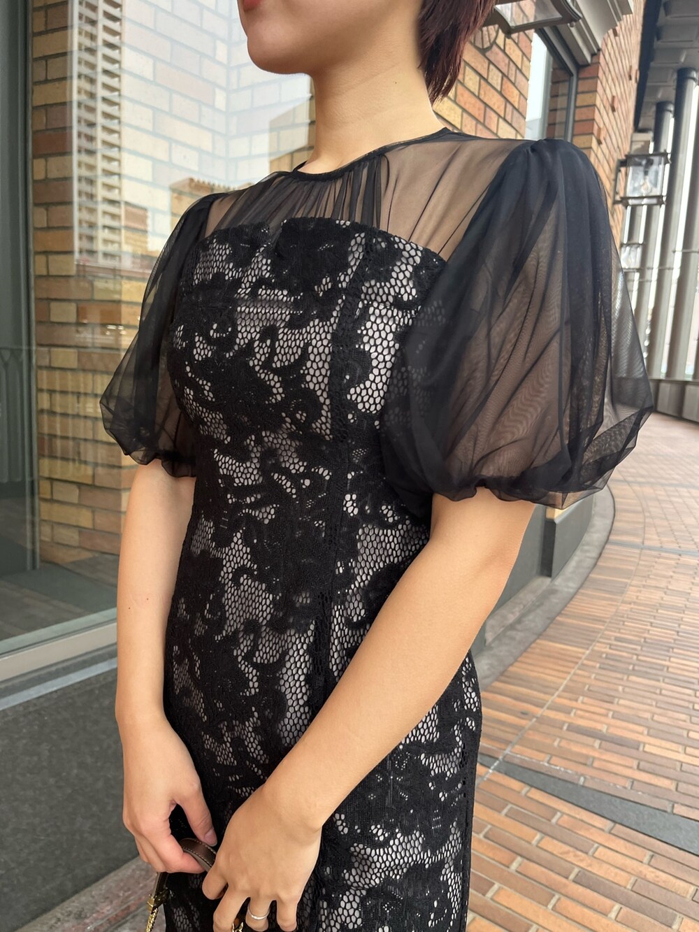 ブラック系のドレス、その他のパンプス、シルバー系のハンドバッグを着用したレディースの冬コーディネートの7枚目の写真