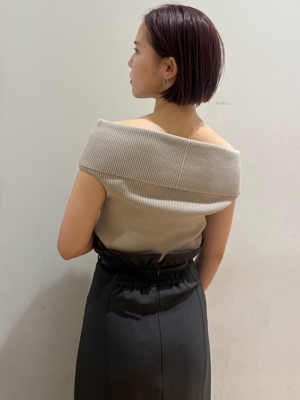 ベージュ系のニット/セーター、ブラック系のサンダル、グレー系のスカートを着用したレディースの夏コーディネートの5枚目の写真