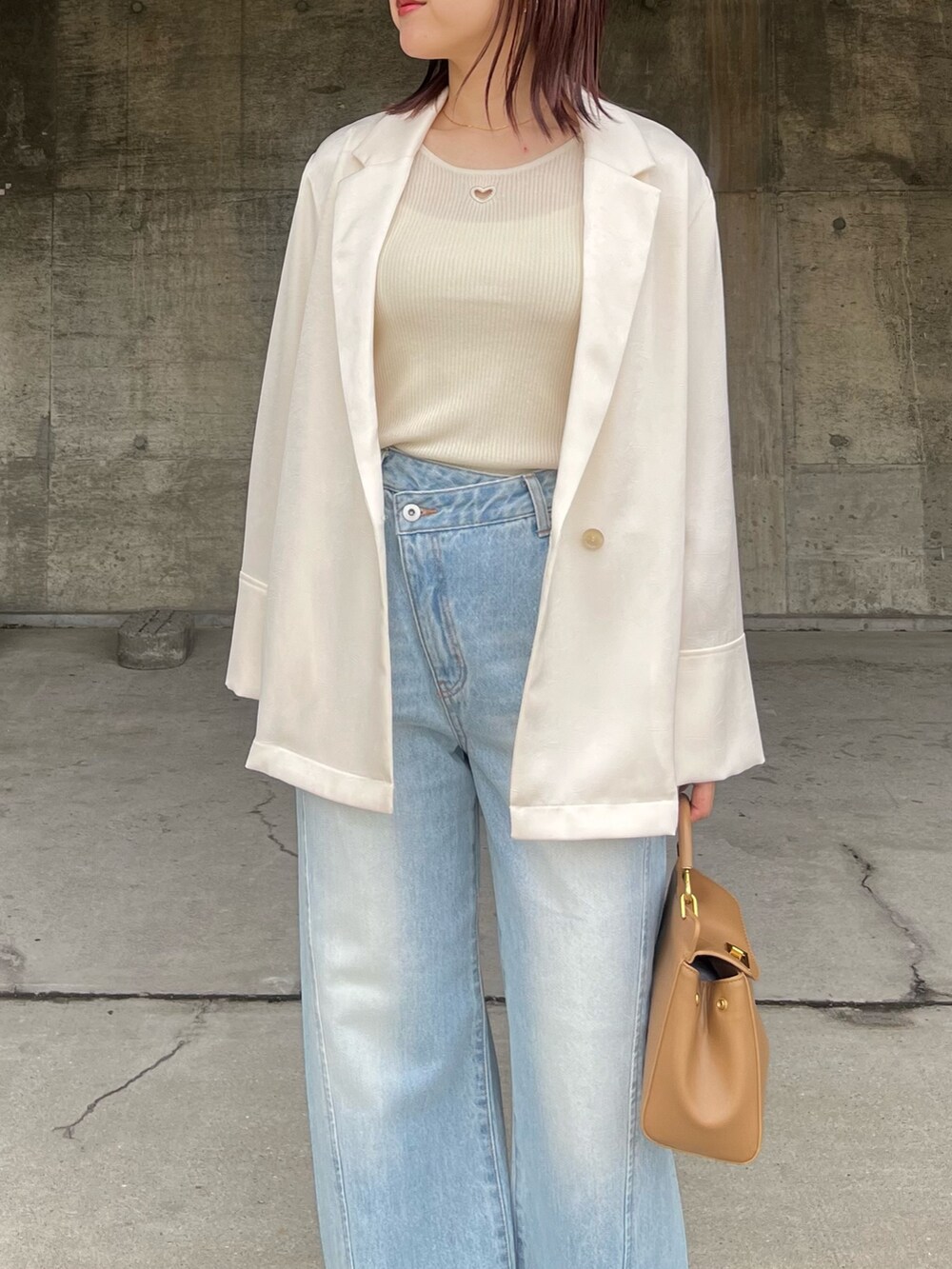 ブルー系のデニムパンツ、シルバー系のサンダル、ブラウン系のハンドバッグを着用したレディースの春コーディネートの4枚目の写真
