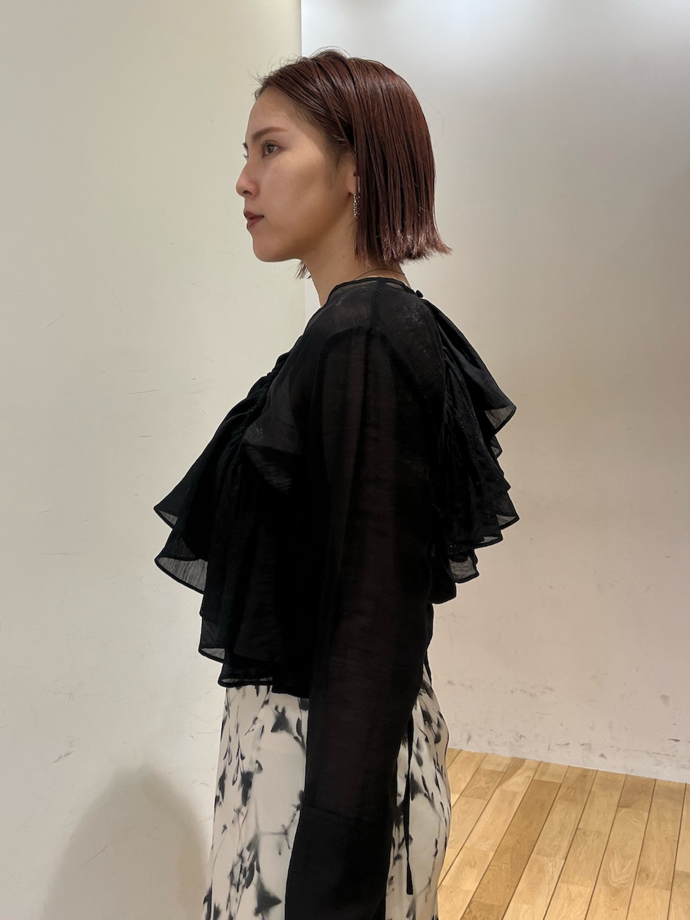 ホワイト系のスカート、レッド系のショルダーバッグ、ブラック系のシャツ/ブラウスを着用したレディースの秋コーディネートの6枚目の写真