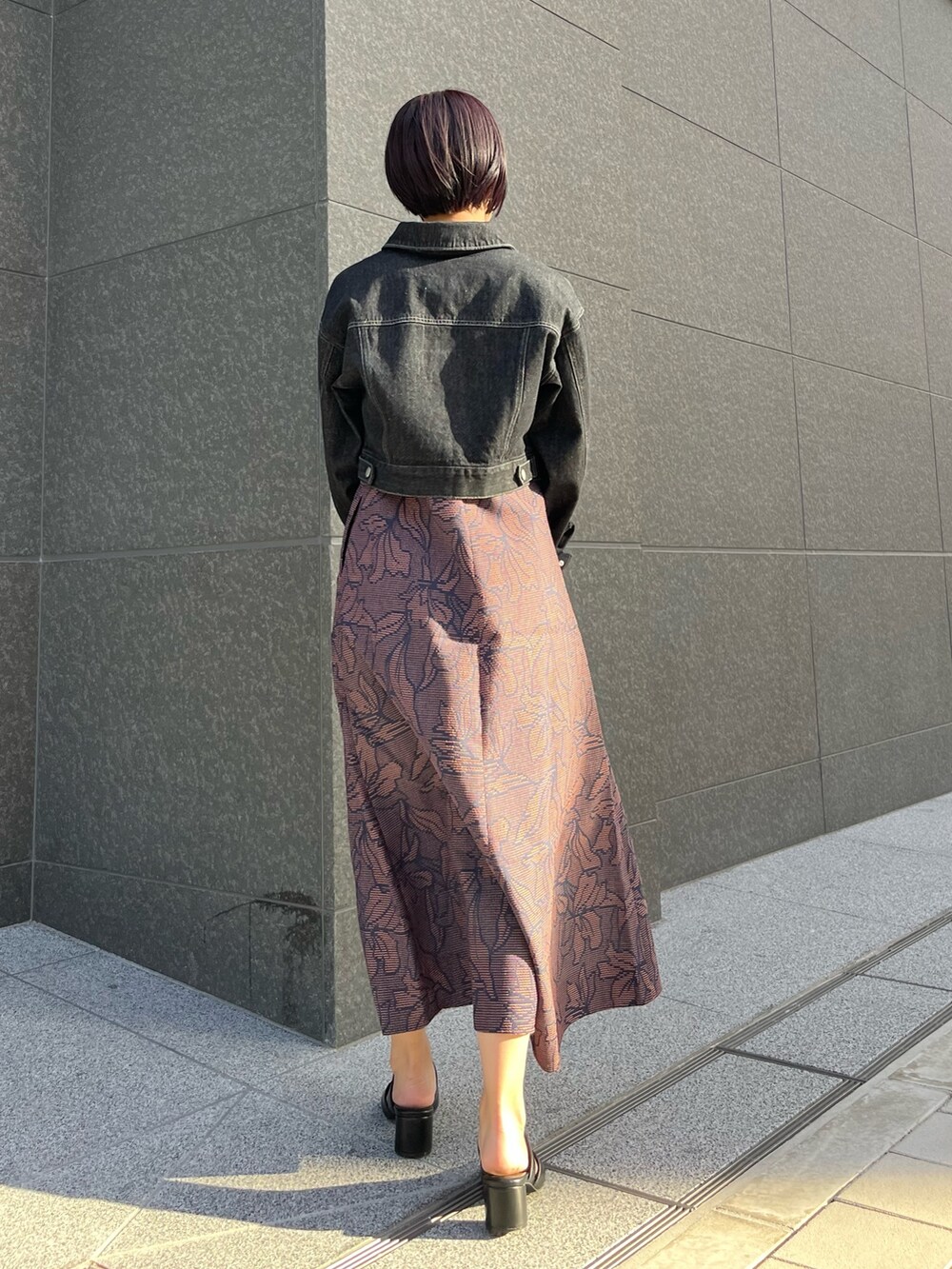 ブラック系のハンドバッグ、ブルー系のワンピース、ブラック系のサンダルを着用したレディースの春コーディネートの4枚目の写真