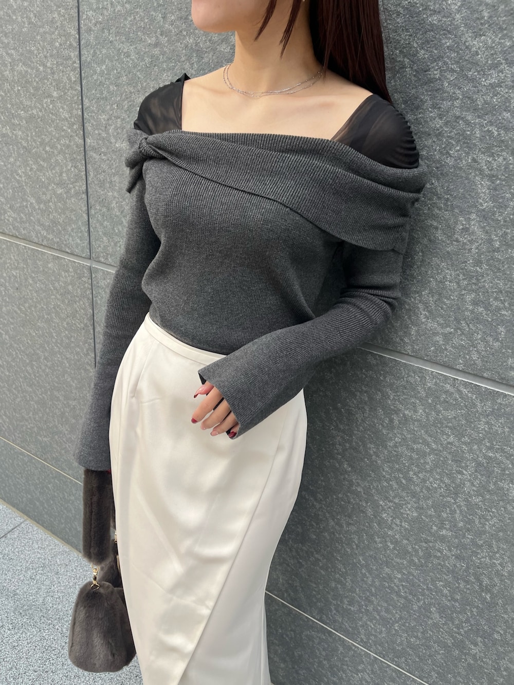 ホワイト系のスカート、ブラウン系のショルダーバッグ、ブラック系のニット/セーターを着用したレディースの冬コーディネートの7枚目の写真