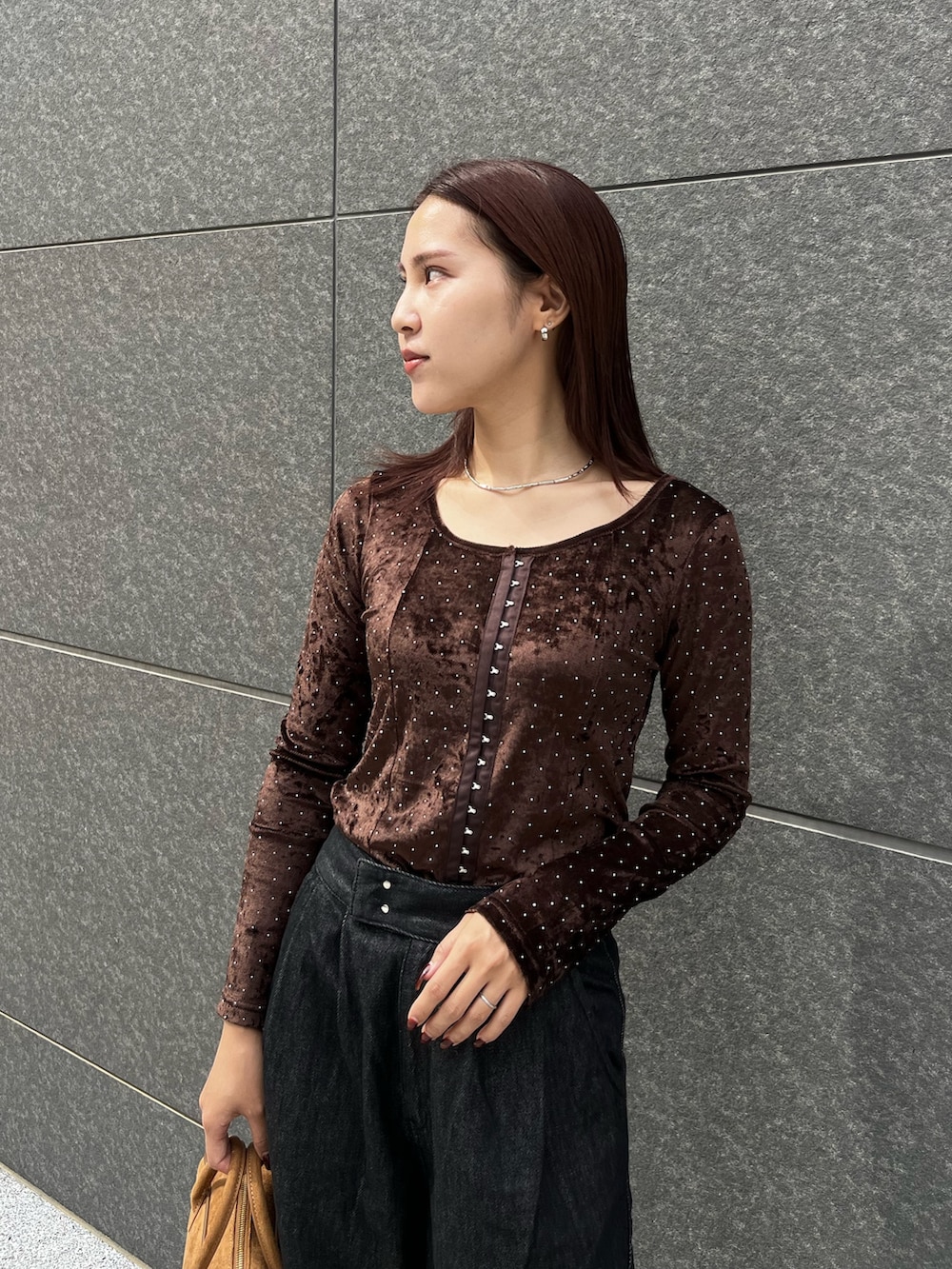 ブラック系のデニムパンツ、ブラウン系のハンドバッグ、ブラウン系のTシャツ/カットソーを着用したレディースの秋コーディネートの4枚目の写真