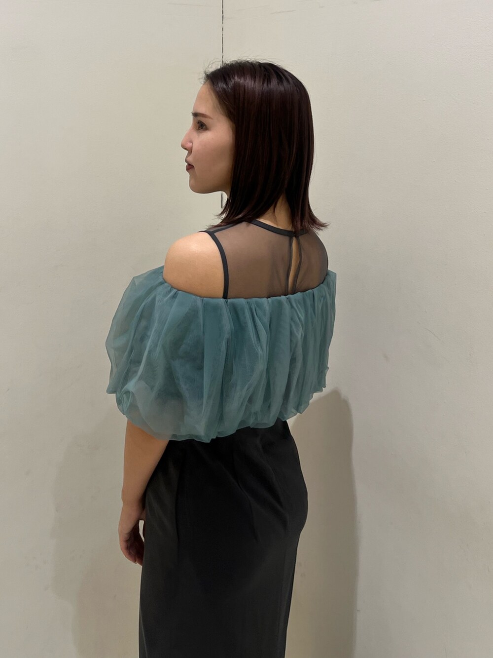 シルバー系のクラッチバッグ、シルバー系のパンプス、グレー系のドレスを着用したレディースの冬コーディネートの5枚目の写真