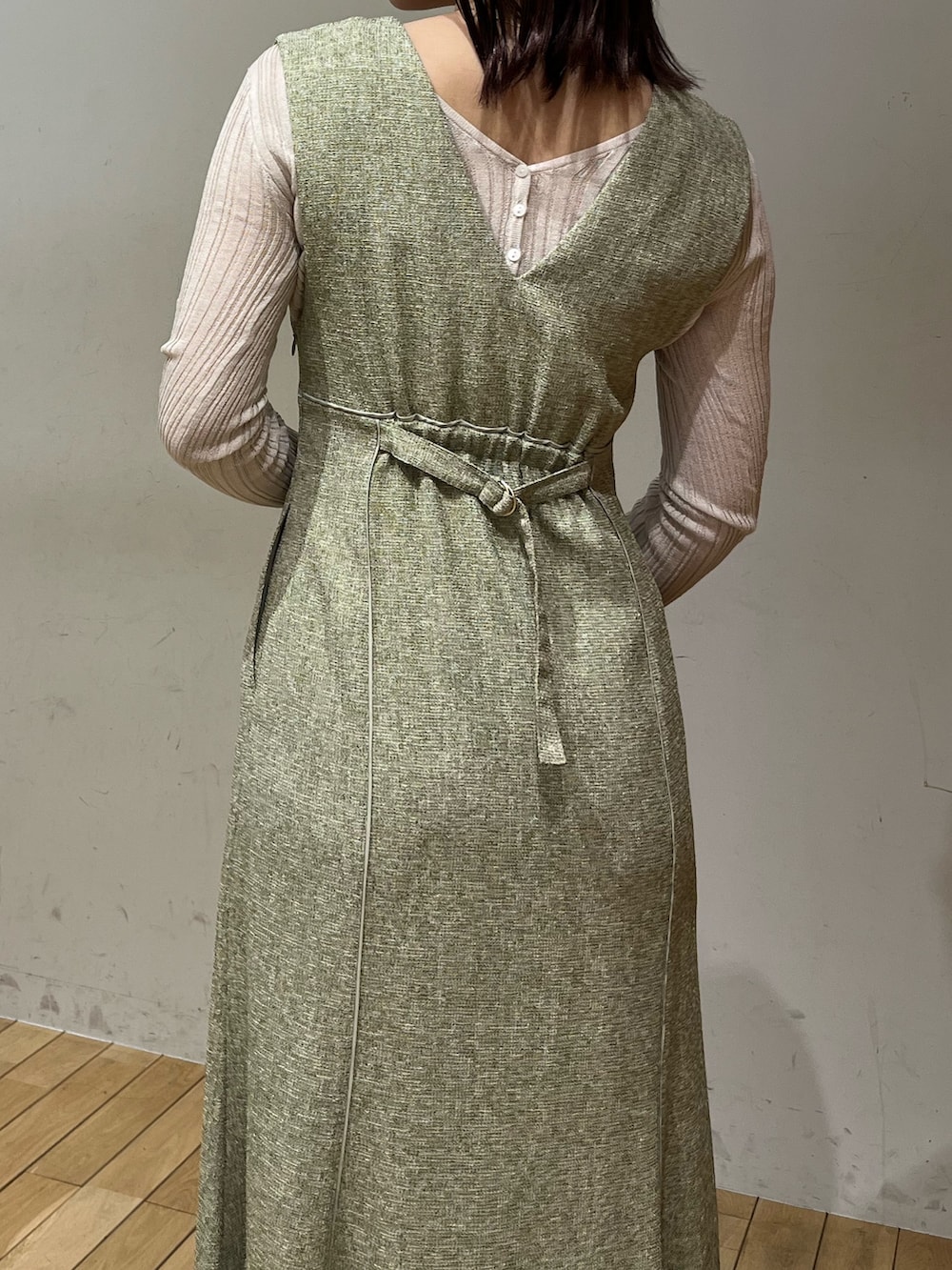 ホワイト系のTシャツ/カットソー、グリーン系のジャンパースカート、ホワイト系のサンダルを着用したレディースの春コーディネートの5枚目の写真